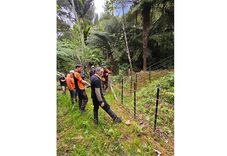 People stand next to fence