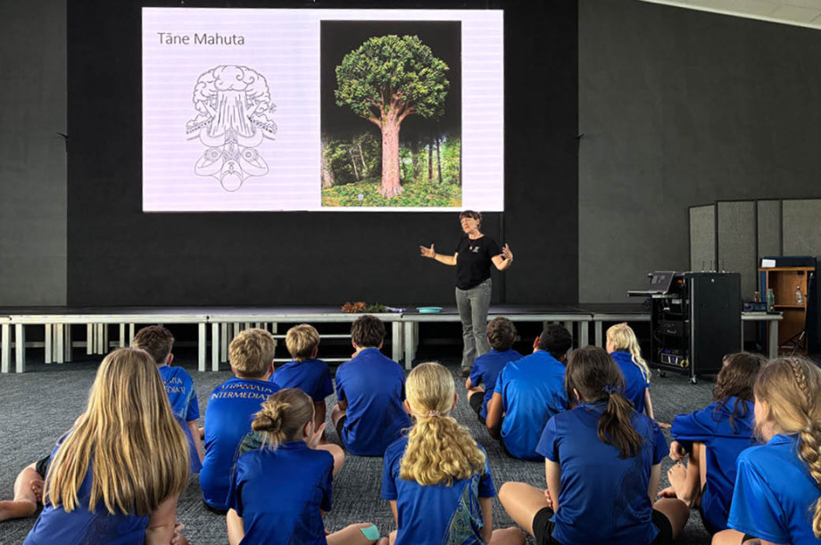 Group of students look to an educator talking about Tāne Mahuta